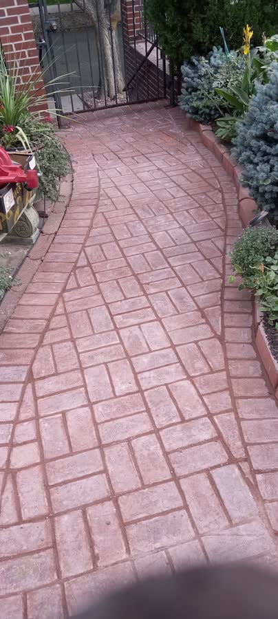 Red stamped concrete walkway in a brick pattern