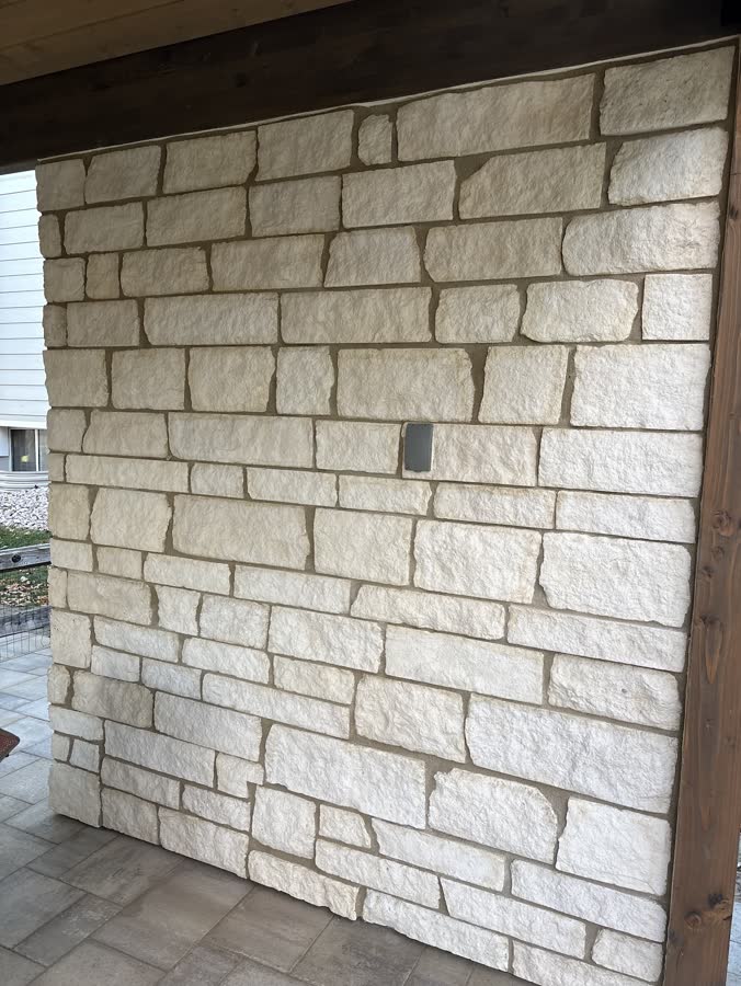Cut limestone wall laid under a porch roof