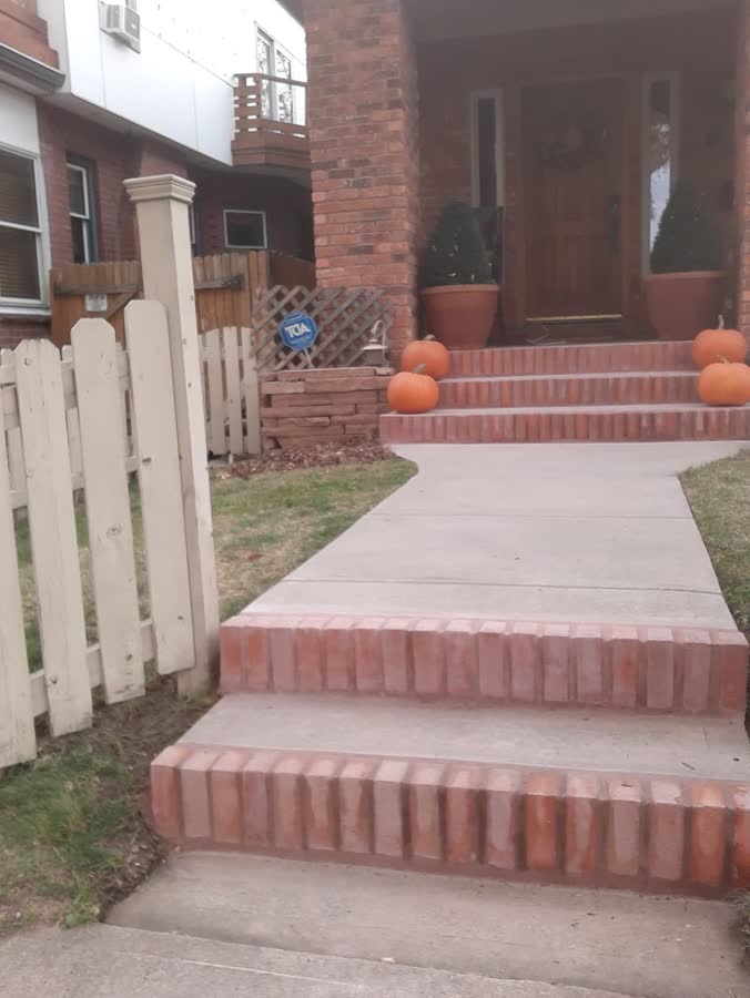 Brick front steps leading onto a new concrete walkway