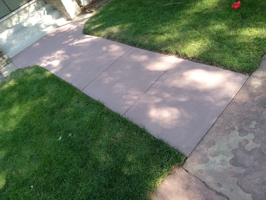 Tinted concrete sidewalk laid through new sod