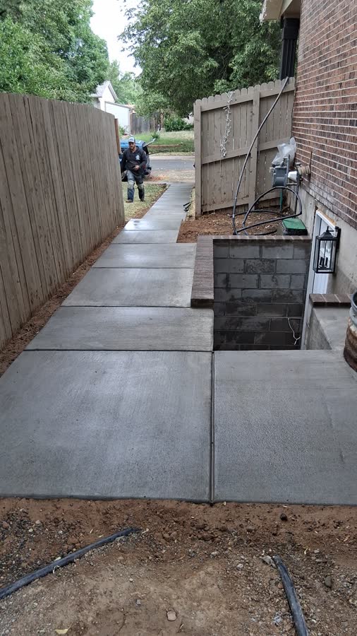 Side yard concrete slab running along a fence