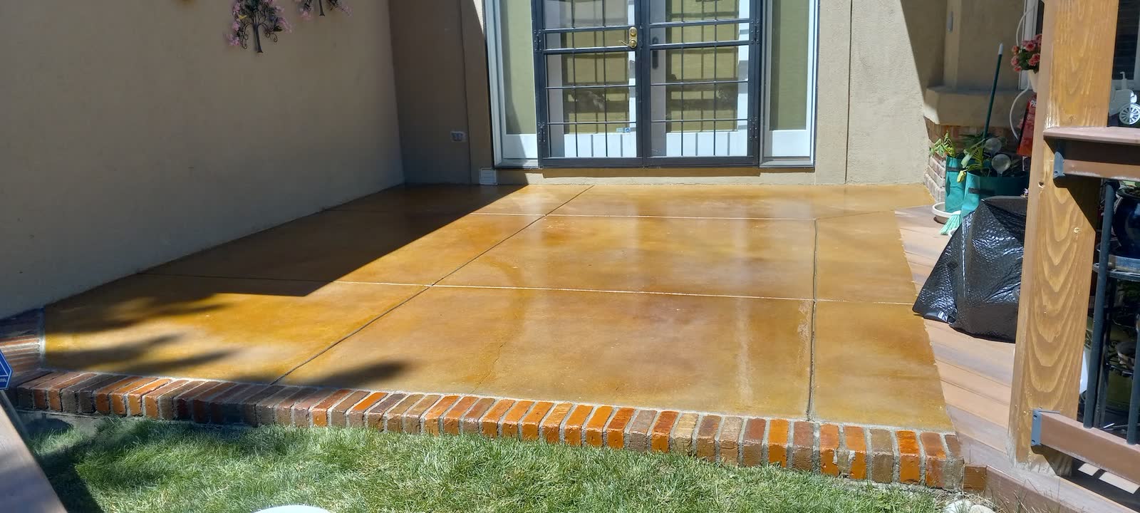 Amber acid stained concrete patio edged with a soldier course of brick