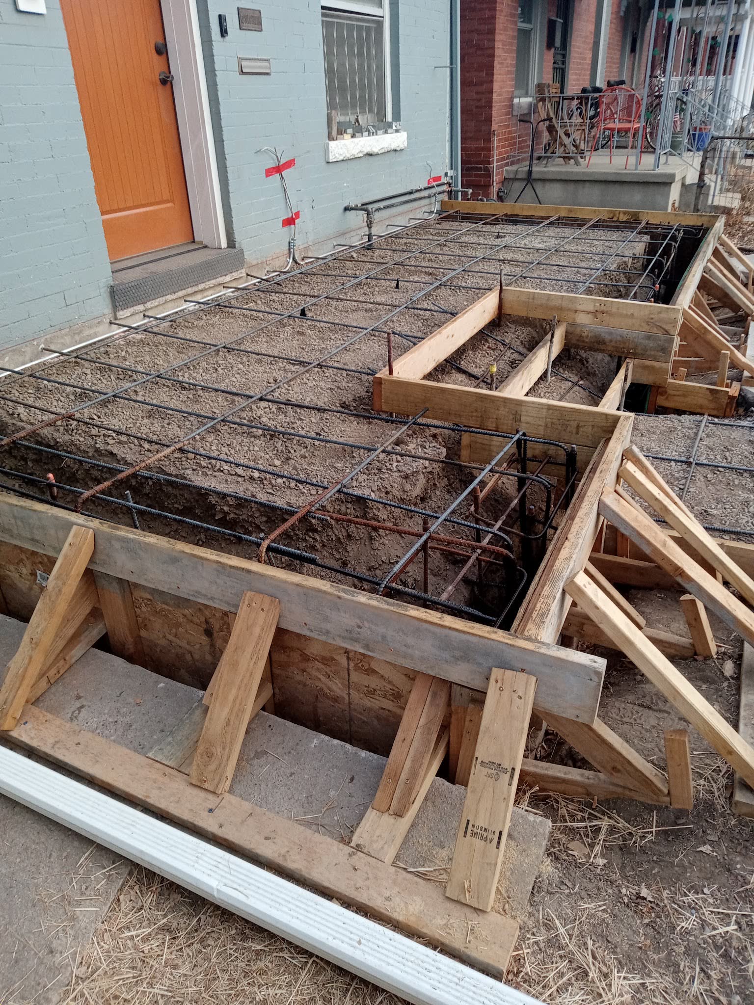 Steel rebar tied inside timber formwork before a concrete pour at a house entry